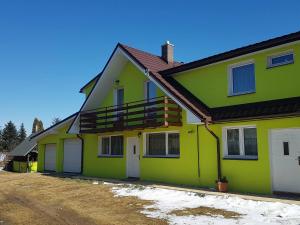 een geel en groen huis met een dak bij Apart-Bungalovy Gitka in Mlynčeky