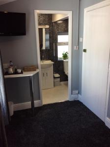 ein Badezimmer mit einem Waschbecken, einem WC und einem Spiegel in der Unterkunft The Westbourne Guest House in Llandudno