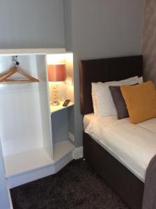 スランディドノにあるThe Westbourne Guest Houseのベッドルーム1室(ベッド1台、テーブルの上にランプ付)