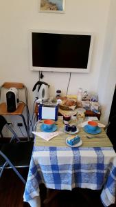 a table with plates of food on it with a television at Bed & Breakfast Le Coste in Massa Marittima