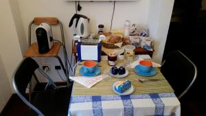 a table with cups and plates of food on it at Bed & Breakfast Le Coste in Massa Marittima