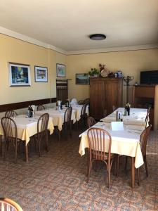ein Esszimmer mit Tischen und Stühlen mit weißem Tischtuch in der Unterkunft Al Pontesel in Garda