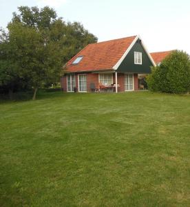 una casa con un césped verde delante de ella en Villa Smalspoor en Markelo