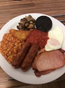a plate of breakfast food with sausage beans and eggs at The Westbourne Guest House in Llandudno