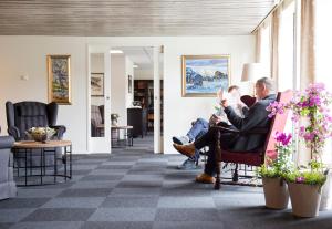 a group of people sitting in chairs in a lobby at Morgedal Hotel - Unike Hoteller in Morgedal