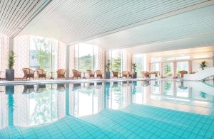 a rendering of a swimming pool with chairs and tables at Morgedal Hotel Spa & Resort - Unike Hoteller in Morgedal
