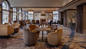 a restaurant with tables and chairs and a fireplace at Glasgow Grosvenor Hotel in Glasgow