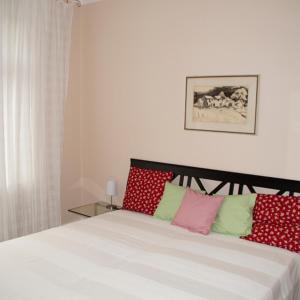 1 dormitorio con 1 cama con almohadas rojas y verdes en Ferienwohnung Appolonia, en Neustadt an der Weinstraße