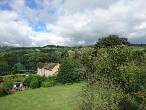 a house in the middle of a field with trees at Plough Cottage in Bradfield