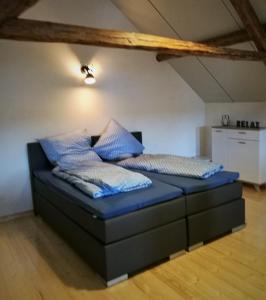 een bed met blauwe lakens en kussens in een kamer bij Beim Hooch "Josef" in Brücktal
