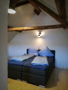 - une chambre avec un lit doté de draps et d'oreillers bleus dans l'établissement Beim Hooch "Josef", à Brücktal