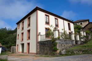 a white house with a stone wall at Casona de La Vega in Vega de los Caseros