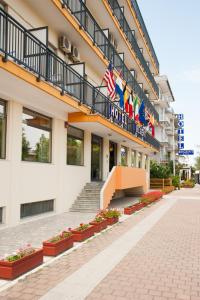 um hotel com bandeiras na lateral de um edifício em Hotel Regent em Pescara