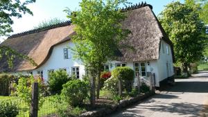 een wit huis met een rieten dak bij "Engelsby-Dorf" in Flensburg