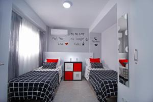 トレ・デル・マールにあるVella Rosa 2の赤と黒の部屋のベッド2台