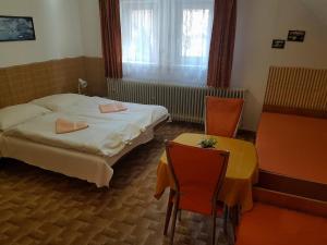 a hotel room with a bed and a table and chairs at Vila Zdenka in Vysoke Tatry - Tatranska Kotlina