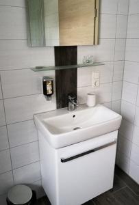 a white bathroom with a sink and a mirror at Beim Hooch "Johanna" in Brücktal