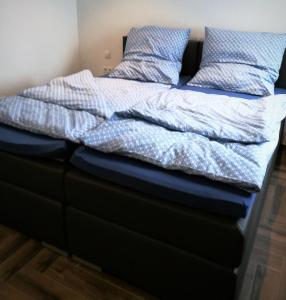 a bed with blue comforter and pillows on it at Beim Hooch "Johanna" in Brücktal