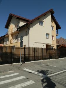 a large white building with a black fence at Garsoniera Luxury in Sibiu