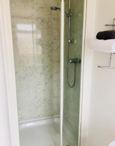 a shower with a glass door in a bathroom at Alder Lodge in Cambridge