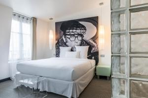 1 dormitorio con 1 cama grande y una pintura en la pared en Kube Hotel Paris, en París