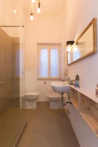 een badkamer met een wastafel, een toilet en een spiegel bij Casitalinda in Lido di Ostia