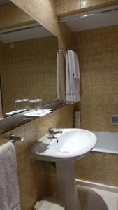 y baño con lavabo blanco y espejo. en Hotel Imperial, en Aveiro