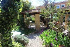 a garden with a bench and a table in it at Hotel restaurant MARTINEZ in Balaruc-les-Bains