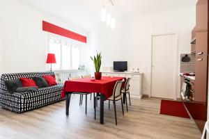 a living room with a red table and a couch at Casa Linda, a due passi dal mare in Numana