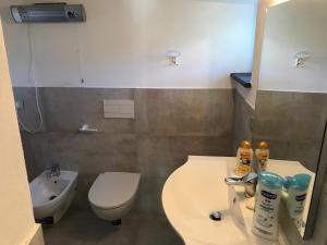 a bathroom with a white toilet and a sink at Cottage in front of the sea in Bonassola