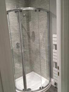 a shower with a glass enclosure in a bathroom at Copperfield Homestay in Cardiff
