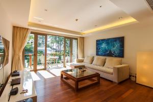 uma sala de estar com um sofá e uma mesa em Nai Thon Beachfront Apartments em Praia de Nai Thon