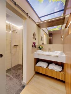 ein Bad mit einem Waschbecken und einer Dusche in der Unterkunft Pfalzhotel Asselheim in Asselheim