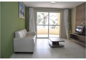 a living room with a white couch and a table at Costa Brava Praia Hotel in Lucena