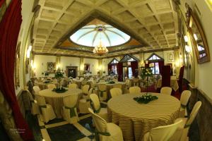 une salle de banquet avec des tables, des chaises et un lustre dans l'établissement Hotel Las Acacias, à Puente-Genil