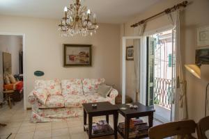 a living room with a couch and a chandelier at Corfu Retreat in Corfu