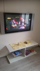 a flat screen tv on a wall with a white table at Ferienwohnung Kieble in Ichenhausen