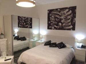 タオルミーナにあるイソコ ゲスト ハウスのベッドルーム(白いベッド、黒い枕付)