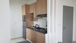 a small kitchen with wooden cabinets and a sink at EVO SOHO DUPLEX Suites in Bangi