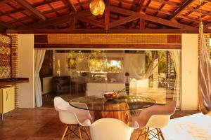 a dining room with a glass table and chairs at Refugios Parajuru - Chalet la Garagem in Parajuru