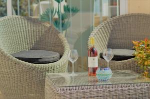 a table with two chairs and a bottle of wine at Villa La Terre Des Lauriers in Vallauris