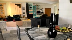 een woonkamer met een tafel met een vaas erop bij Friendly Family House in Volos