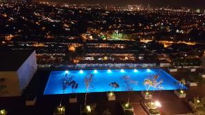 a night view of a swimming pool with lights at EVO SOHO DUPLEX Suites in Bangi