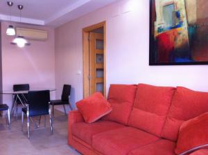 a living room with a red couch and a table at Atico Duplex con parking propio in Peniscola