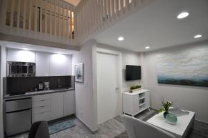 a kitchen with white cabinets and a table with chairs at Modern Loft wQueen Loft Steps to Beach in Hollywood