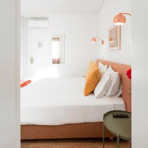 a bedroom with a white bed and white walls at Lisbon Serviced Apartments - Chiado Emenda in Lisbon
