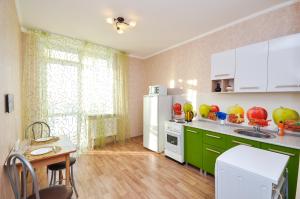ペルミにあるВыше МИРАのキッチン(緑のキャビネット、白い冷蔵庫付)