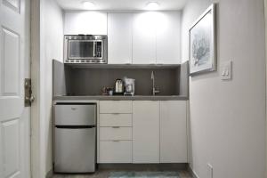 a kitchen with white cabinets and a microwave at Loft wqueen loft beach steps in Hollywood +16 photos