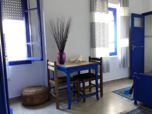 a blue table and chairs in a room with a vase at El Muniria in Tangier