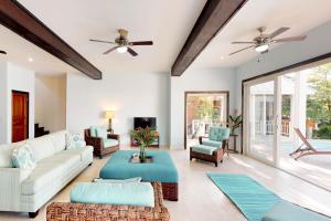 sala de estar con sofá, sillas y ventilador de techo en Private beachfront paradise Palmetto Bay, en Palmetto Bay